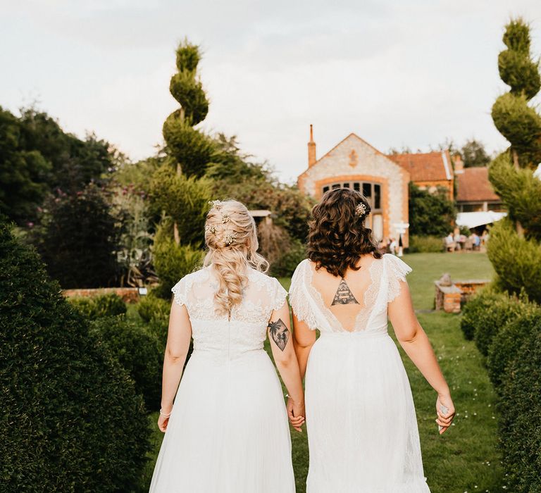 Brides walk towards their venue together with cool tattoos 