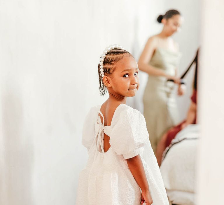 Cute flower girl in love heart print converses, white puff sleeve dress, pearl headband and white wicker basket