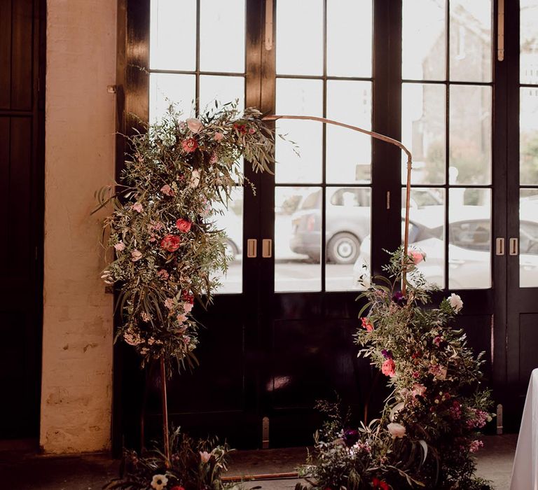 Copper frame altar decoration with pink, red and purple flower arrangement decoration