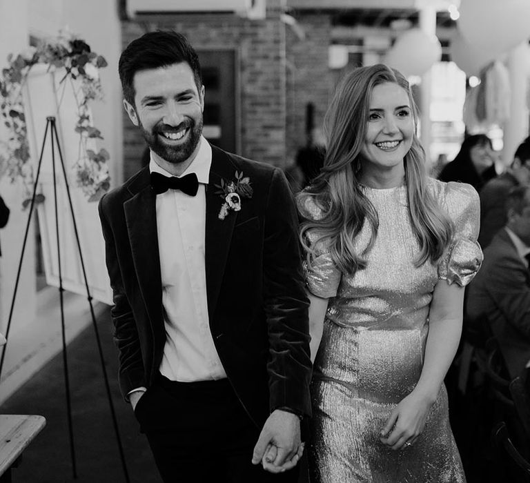 Bride and groom stroll into their wedding reception at 100 Barrington 