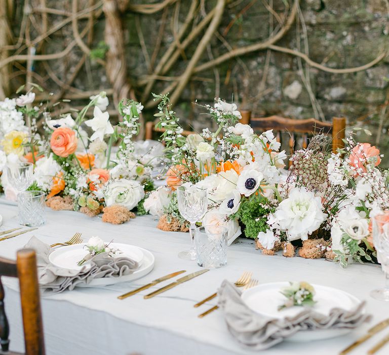 wedding table decor with white crockery, crystal glassware, linen napkins and floral centrepiece 