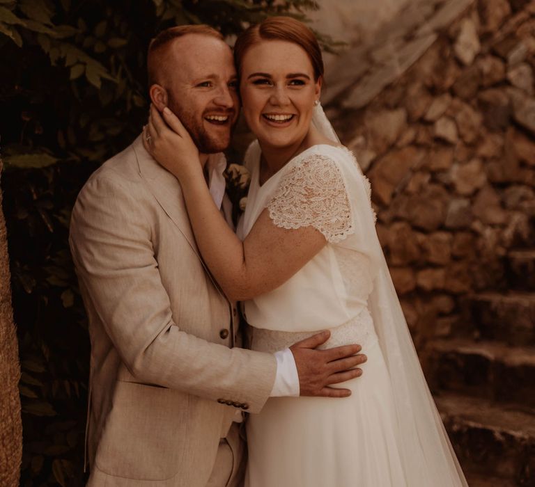 Bride & groom stand outdoors in Spain on their wedding day for relaxed and intimate reception 