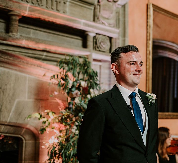 Groom wears morning suit with blue tie and floral pastel coloured buttonhole 