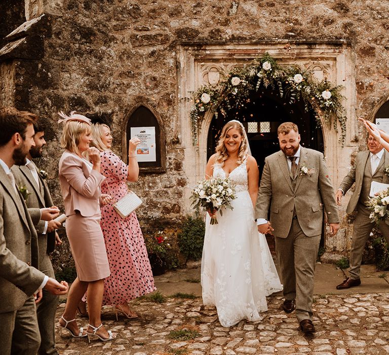 The bride and groom have a confetti moment as they exit church 