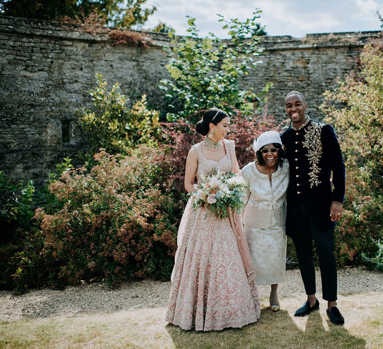 Bride and Groom pose with Mother of the Groom in family wedding photo