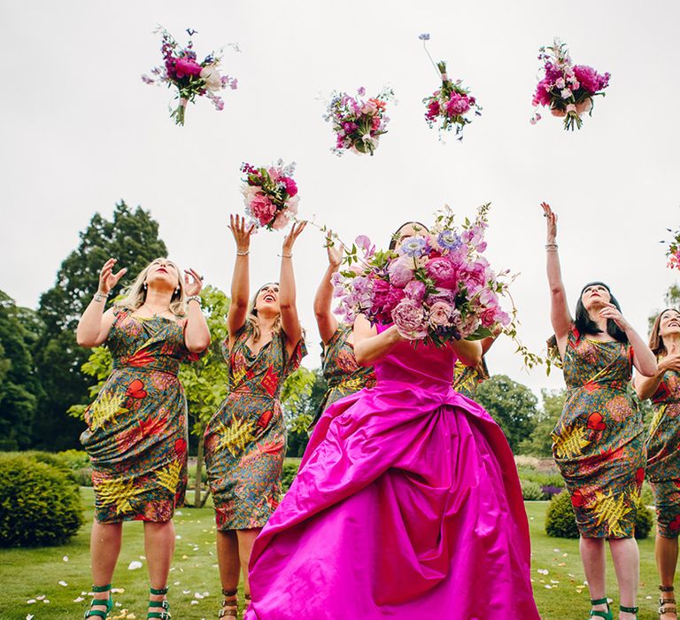 Bride in off the shoulder front ruching pink Vivienne Westwood wedding dress holding pink floral bouquet with pink peonies, fuchsia roses, lilac sweet peas and green foliage