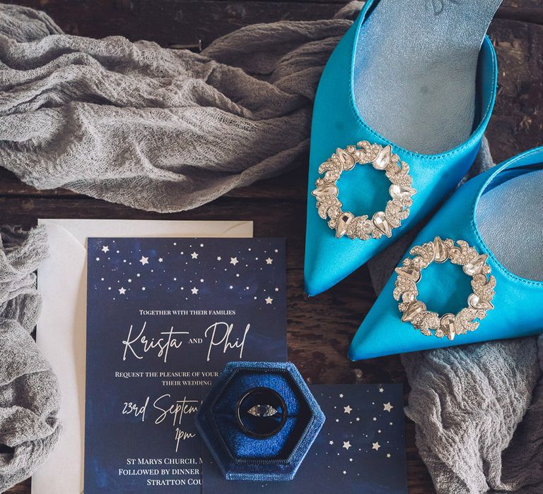 Midnight blue celestial moon and star themed wedding stationery and invitation with blue velvet ring box holding the wedding band and engagement ring with the bride's blue shoes