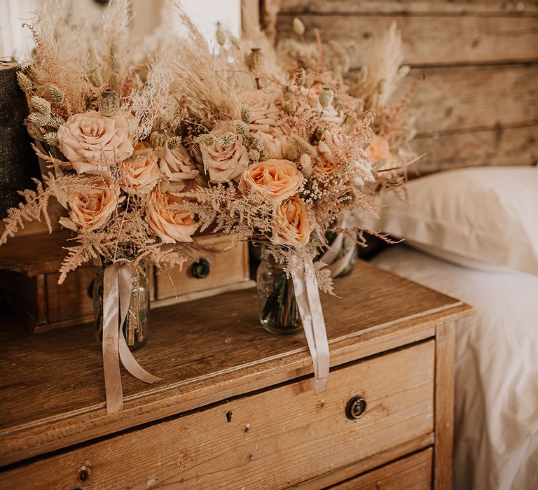 The oversized bridal bouquet made with pink roses, bunny grass, and pampas grass 