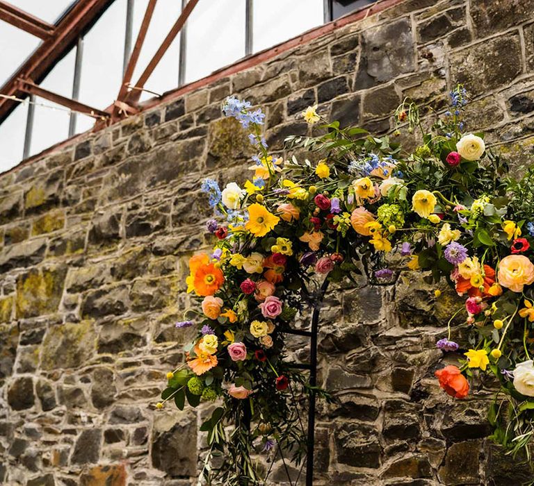 Spring floral archway beside industrial brick wall 