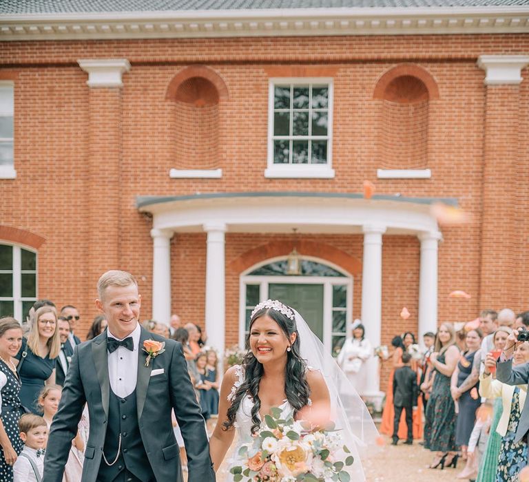 Confetti exit for bride and groom at classic Reymerston Hall wedding in Norfolk 