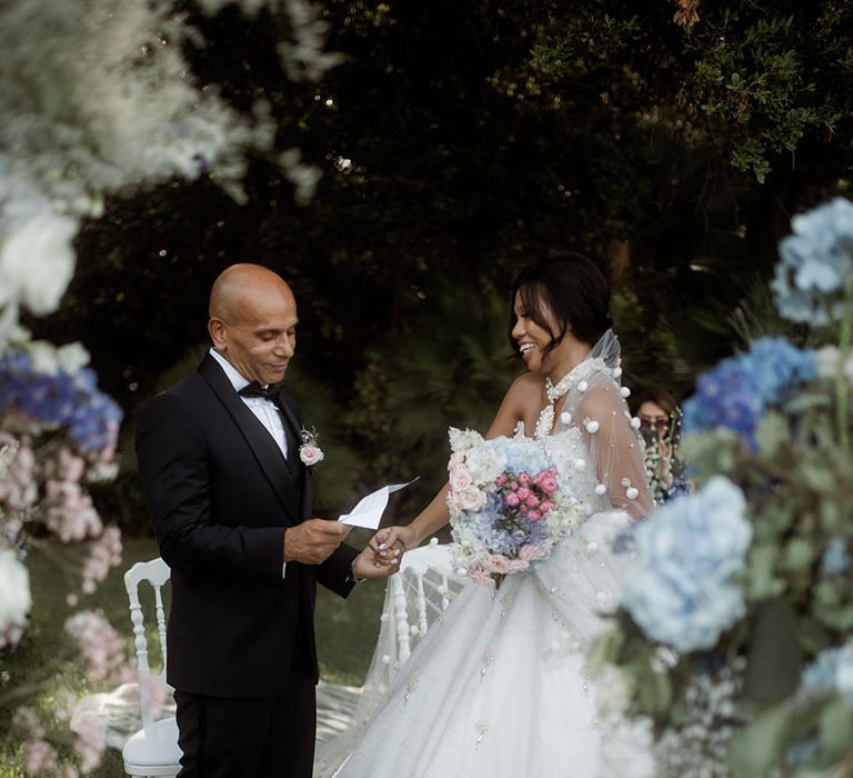 Pastel blue wedding flower decor with bride and groom standing for outdoor wedding 