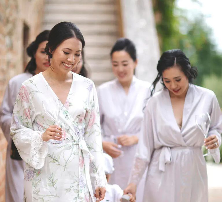 Bridal party wearing white, floral, pastel lilac satin robes by Alessandro Mari Photography