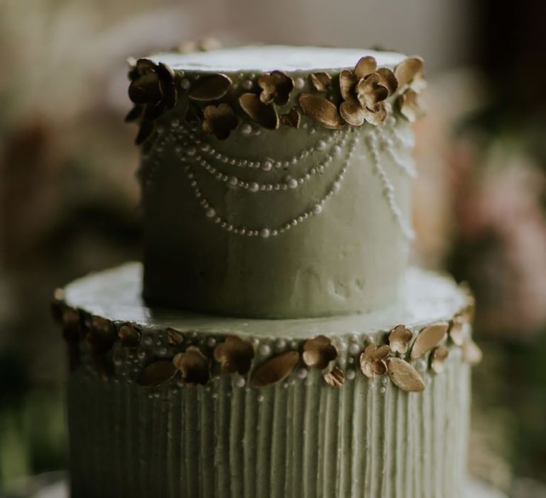 Two tier sage green iced wedding cake with pearls and gold flowers 