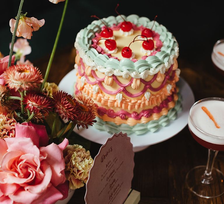 Single tier retro wedding cake with vintage style icing topped with maraschino cherries 