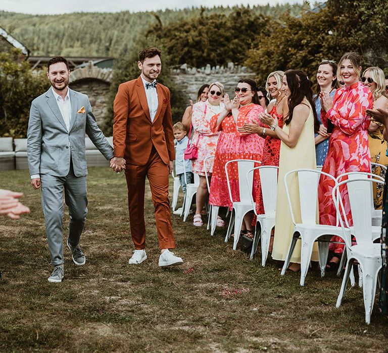 Two grooms walk down the aisle at Wilde Lodge outdoor ceremony 