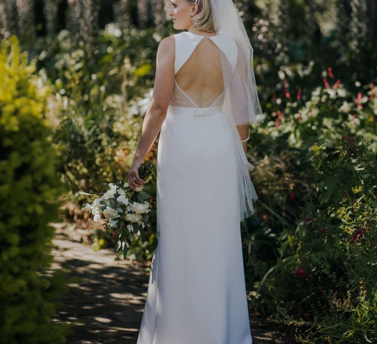 Groom in backless White by Vera Wang wedding dress