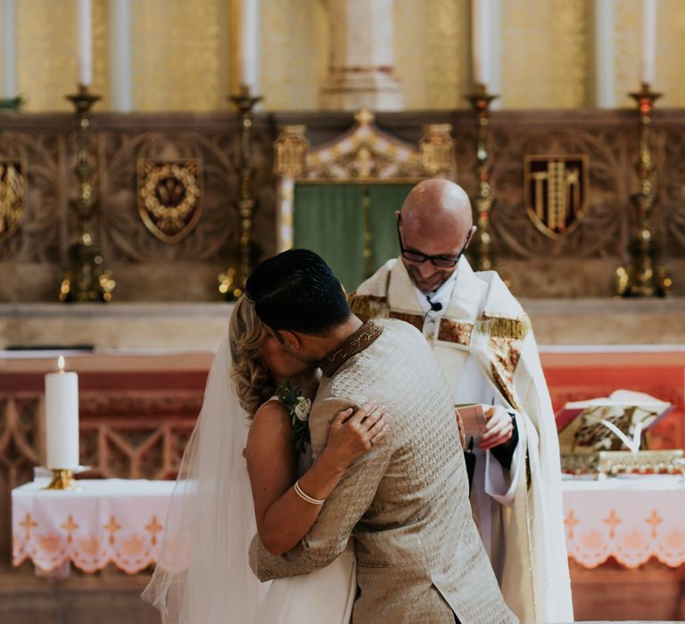 bride and groom embracing at the altar 