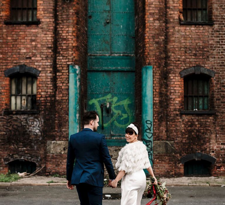 Groom in trouser suit and turban headband walking through the streets at Liverpool wedding 