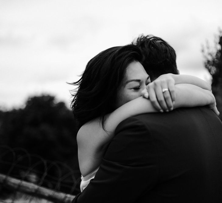 Black and white portrait of bride and groom embracing 