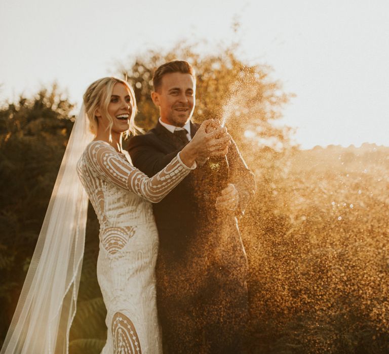 Bride and groom popping champagne at their micro wedding 