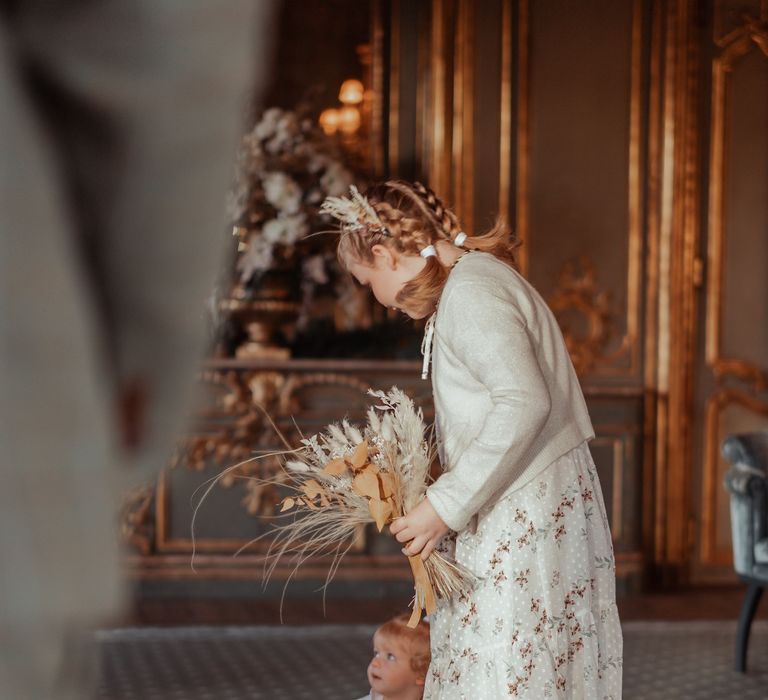 Flower girl holds dried floral bouquet 