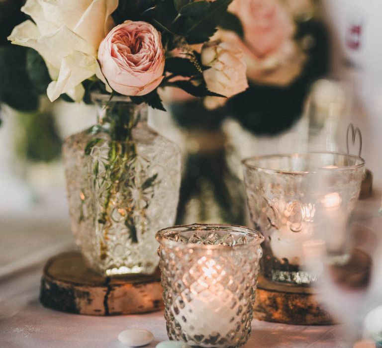 Pink and white roses table decorations surrounded by tealights