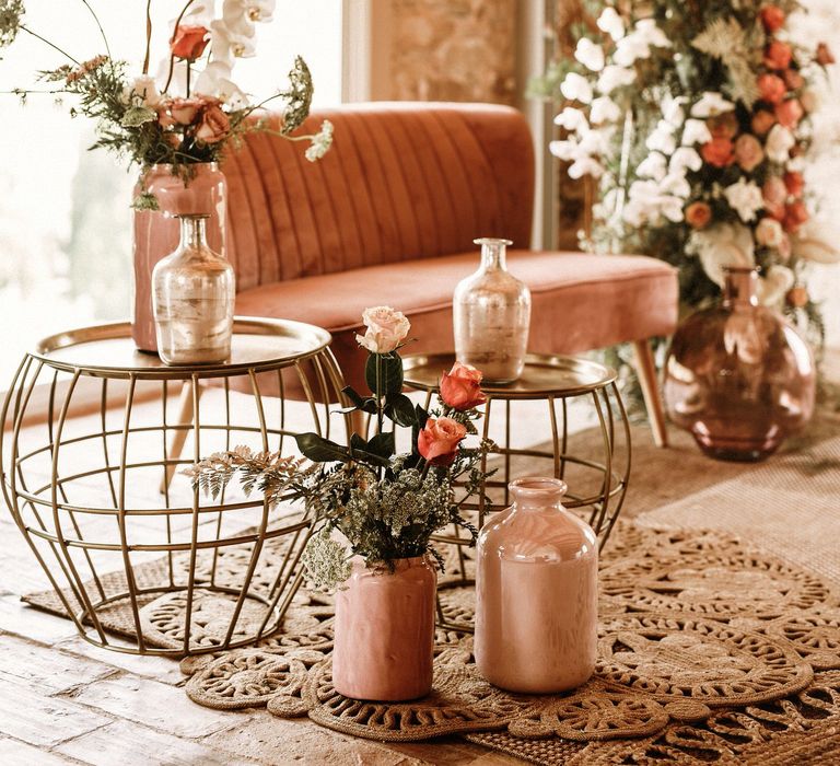 Seating area with pink velvet love seat, and gold wire tables 