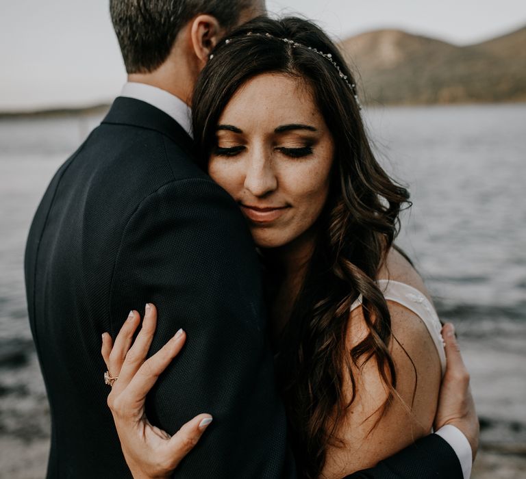 Bride smiles as she embraces her groom