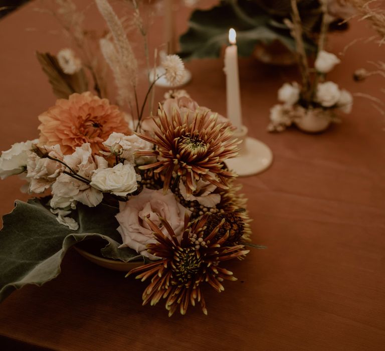 Pink and orange wedding table centrepiece flowers and candles 