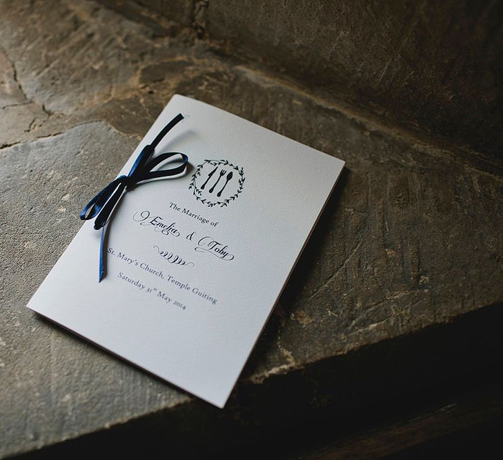 Minimal culinary wedding order of service with a blue ribbon photographed by John Day Photography