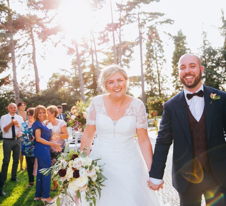 The bride and groom exiting their ceremony, laughing and smiling hand in hand