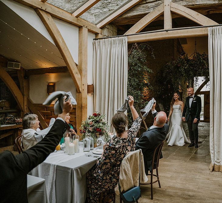 Bride and groom entering the intimate wedding breakfast at Cripps Barn