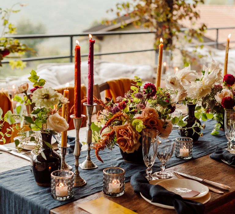 Luxe rustic wedding table in Italy with tapered candles, and earthy toned florals