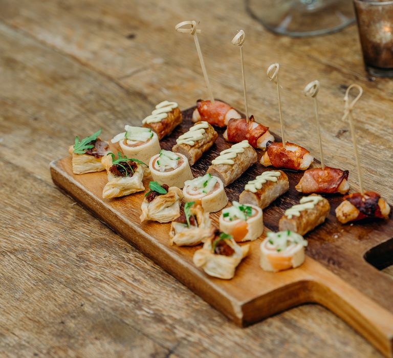 Canapés for wedding reception on rustic wooden board 