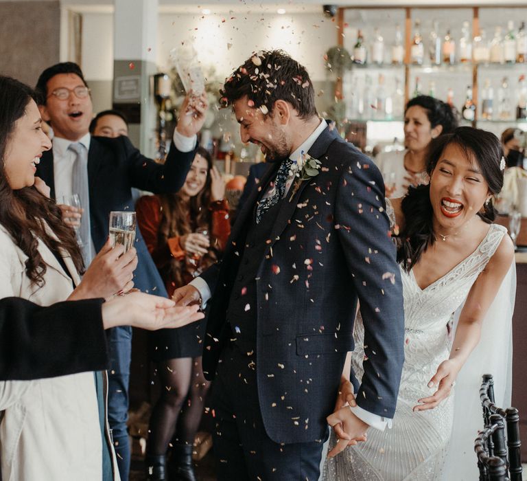 Bride and groom having confetti thrown over them at their wedding reception