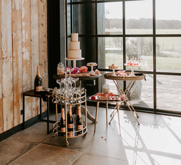 Champagne drinks trolley and wedding dessert table 