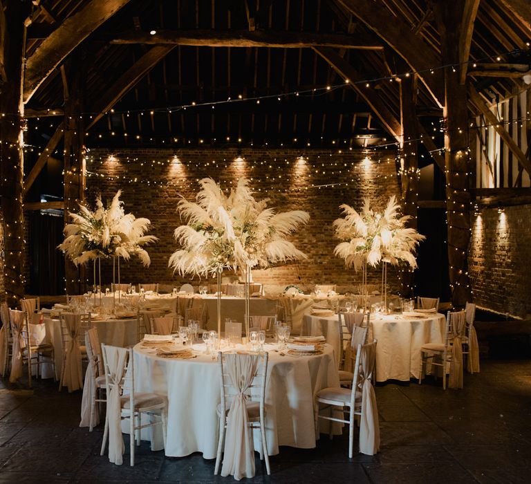 Intimate Cooling Castle Barn wedding reception decor with fairy lights, pampas grass centrepiece and acrylic signs 