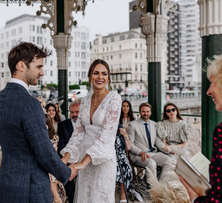 Bride and groom hold hands during wedding in Brighton