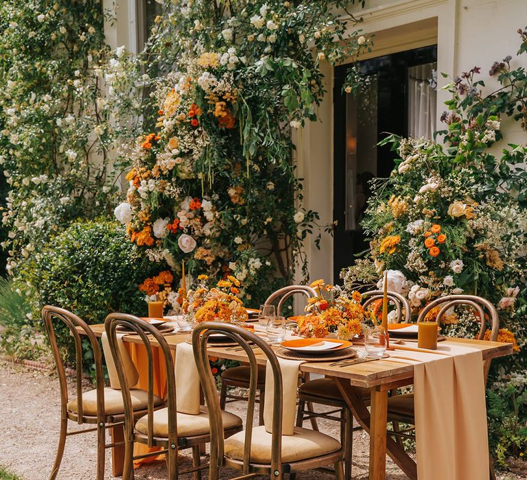 Outdoor wedding reception with orange flower, linen table cloth and table decor 