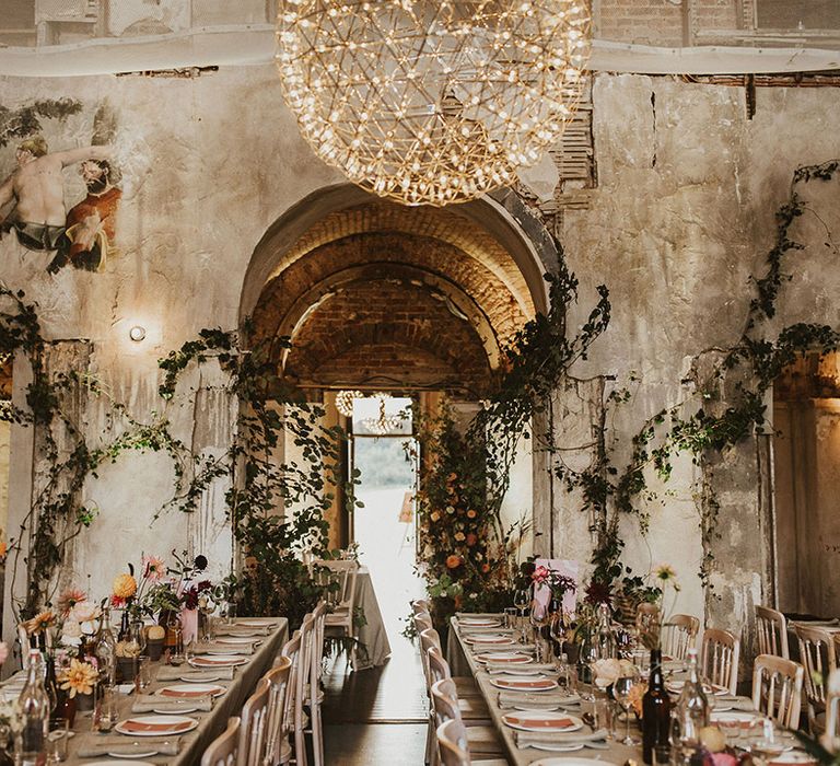 Rustic venue complete with floral vines climbing the walls and pastel florals along tables