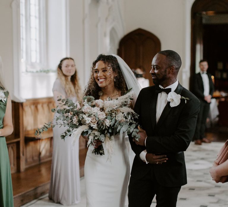 Bride walks down the aisle with her father on her wedding day