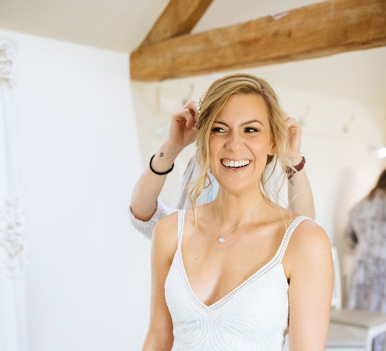 Bride in a fitted Made With Love Bridal gown with embellished design and straps 