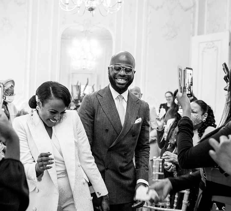 Bride & groom walk through wedding party as they smile during wedding ceremony