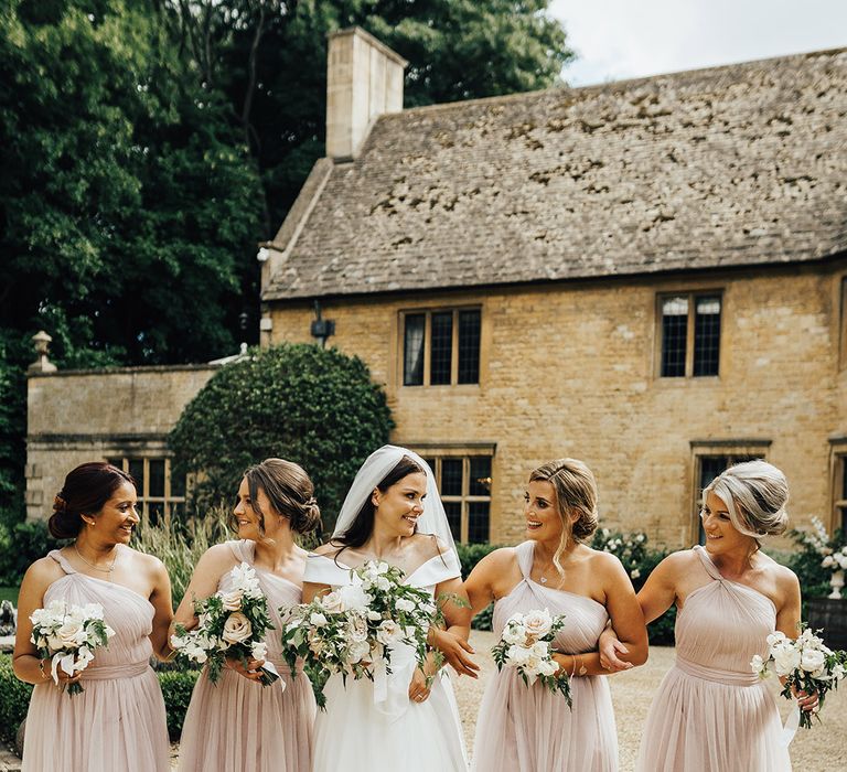 Bridal party in dusky pink bridesmaid dresses and bride in a Suzanne Neville wedding dress at Foxhill Manor luxury wedding venue 