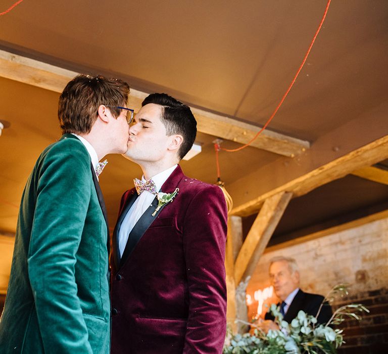 Grooms share their first kiss as a married couple in matching velvet tuxedo jackets