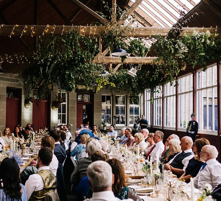 Guests all turn and listen raptly for the wedding speeches 