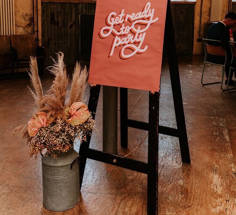 70s inspired wedding sign reading 'get ready to party' with autumnal flowers