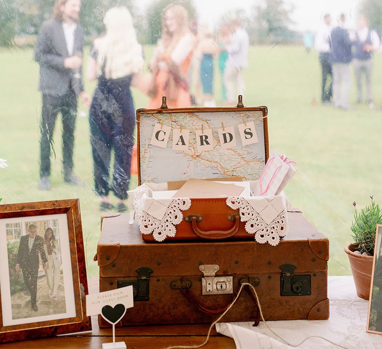 Vintage suitcases on wooden table with printed letters across inside in marquee 