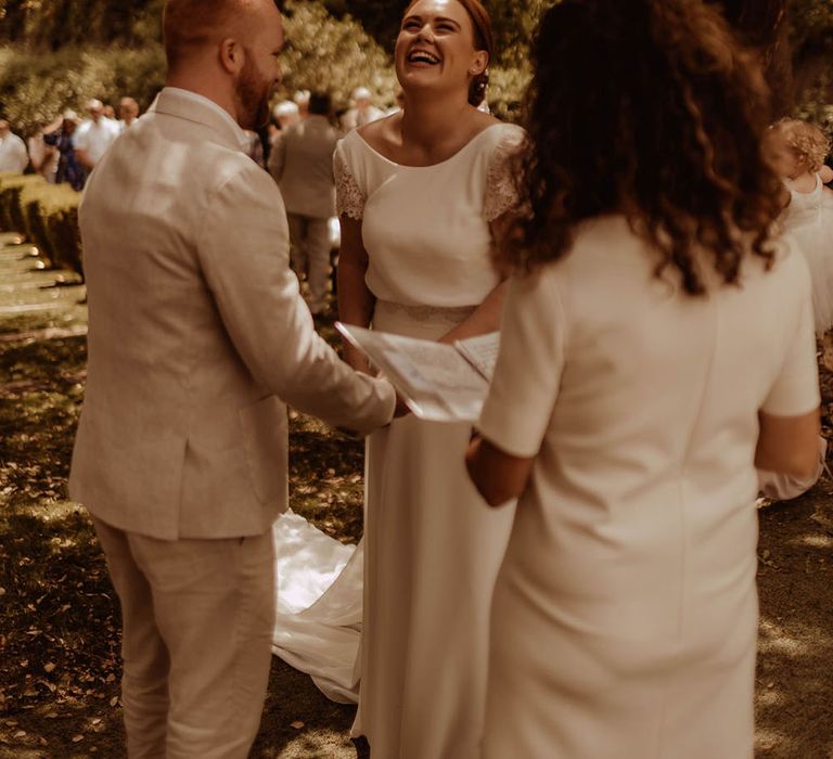 Bride laughs during wedding ceremony outdoors for Spanish wedding 