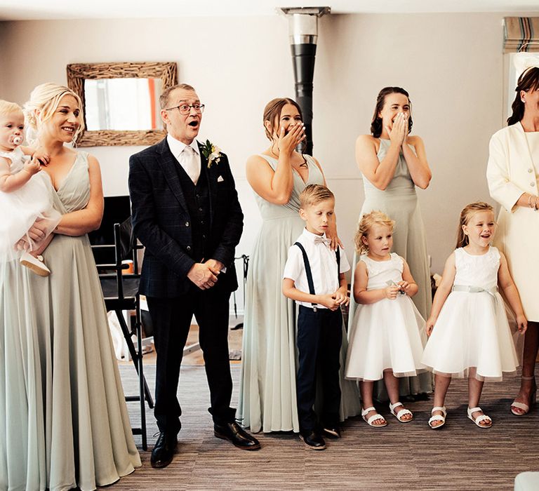 Mother and father of the bride with some bridesmaids and flower girls and a page boy get their first look 